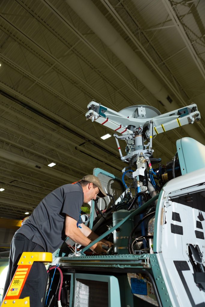A male employee is working on a helicopter part at an Airbus Helicopters facility in Mississippi