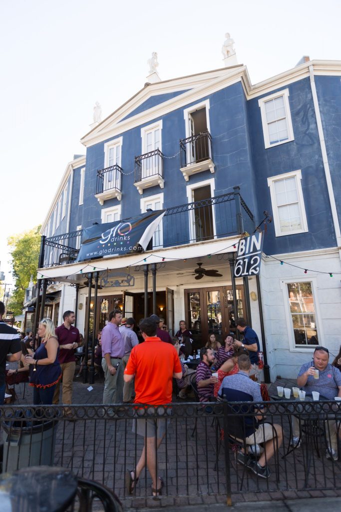 An exterior shot of the Bin 162 restaurant with groups of people sitting at outdoor seating arrangmeents in Mississippi