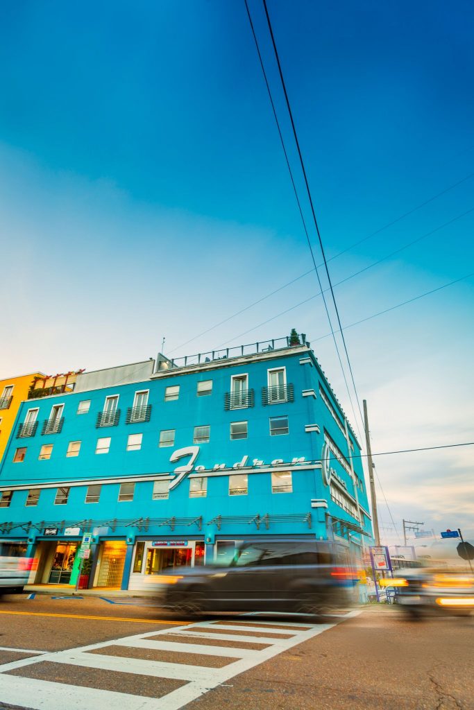 A vibrant blue building with Fondren in silver, script font and a blurry car passing by in Mississippi